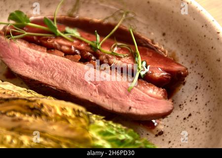 Mise au point douce.Entrecote boeuf steak grillé viande avec flammes de feu sur bois coupé avec branche de laitue, poivre et sel .Chef cuisinier maître cuisine de Banque D'Images