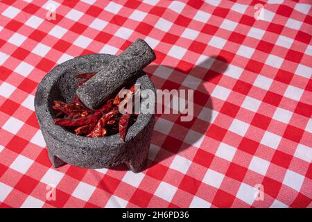 Gros plan de piment rouge séché avec mortier et pilon. Banque D'Images