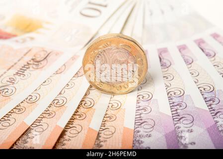 Argent: Une et deux pièces de livre se sont assis sur des billets de dix et vingt livres.£1 £10 £20 Livre Sterling devise.Gros plan, arrière-plan. Banque D'Images