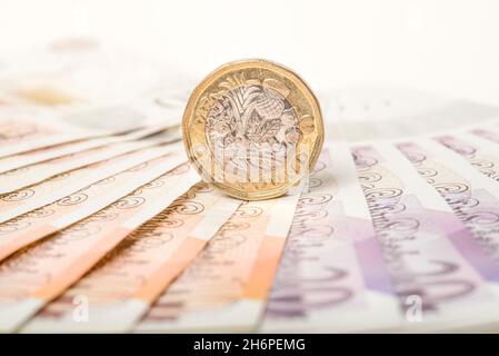 Argent: Une et deux pièces de livre se sont assis sur des billets de dix et vingt livres.£1 £10 £20 Livre Sterling devise.Gros plan, arrière-plan. Banque D'Images
