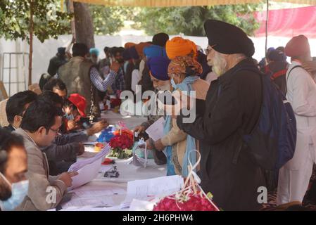 Lahore, Punjab, Pakistan.17 novembre 2021.Les pèlerins sikhs indiens affluent vers les journalistes tout en entrant au Pakistan par le point de passage frontalier de Wagha, près de Lahore.Trois milliers de pèlerins sikhs indiens sont arrivés au Pakistan pour participer à un festival à Nankana Sahib près de Lahore, pour célébrer le 552e anniversaire de naissance de leur chef spirituel Sri Baba Guru Nanak Dev, le fondateur de la religion sikh.(Credit image: © Rana Sajid Hussain/Pacific Press via ZUMA Press Wire) Banque D'Images