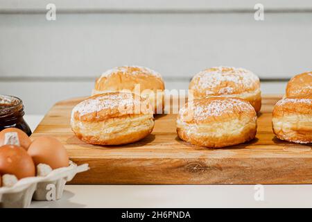 Cuisson de beignets ou de sufganiyot d'Hanoukkah.Bonbons traditionnels pour les fêtes juives.Dessert berlinois frais dans la cuisine maison. Banque D'Images