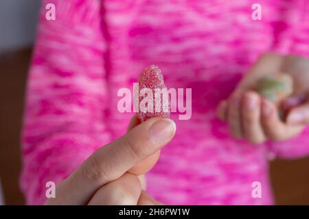 Femme tenant des bonbons, photo de gros plan de bonbons en gelée dans la main de fille. Banque D'Images