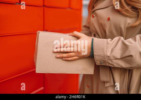 Person using automated self service post terminal machine or locker to deposit the parcel for storage. Freight transportation. Express delivery. Stock Photo