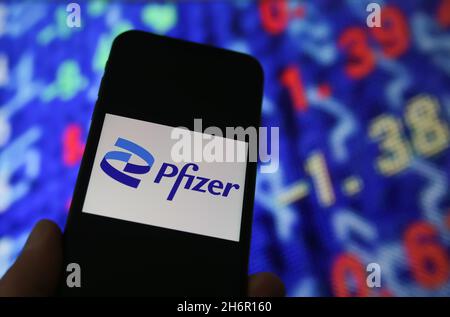 Viersen, Allemagne - juin 6.2021: Gros plan de l'écran de téléphone mobile avec logo lettrage de Pfizer, fond de graphique boursier Banque D'Images