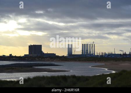 Superbe image couleur montrant la vue sur Tees Bay vers la centrale électrique EDF Hartlepool et les pôles de turbine éolienne au port voisin d'Able Seaton. Banque D'Images