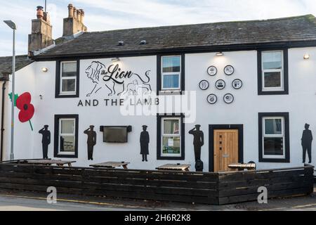 Souvenir des sihouettes de coquelicot et de soldat sur un mur de pub, le Lion et l'Agneau dans le village de Gosforth, Cumbria, Royaume-Uni, pour marquer le jour de l'armistice, le 2021 novembre Banque D'Images