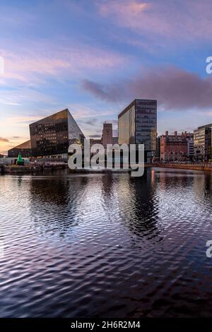 En début de soirée, avec les nouveaux bâtiments spectaculaires et branchés de Liverpool One, qui se reflètent dans Canning Dock, dans l'historique Albert Dock de Liverpool. Banque D'Images