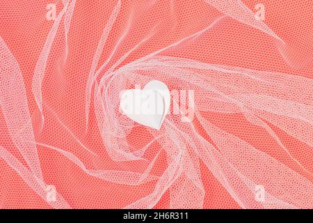 Saint-Valentin composition de coeur en papier sur fond rouge avec tulle transparent, plat Banque D'Images