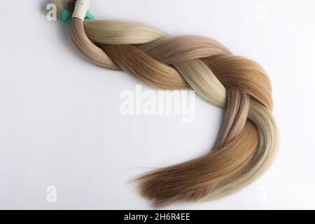 Sections de cheveux pour femmes pour l'extension tressée dans la queue, sur le fond blanc. Banque D'Images