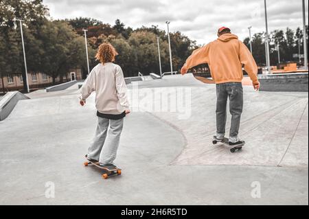 Une fille et un gars skate avec dos à la caméra Banque D'Images