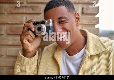 Souriant jeune homme photographe se sentant bien et content Banque D'Images