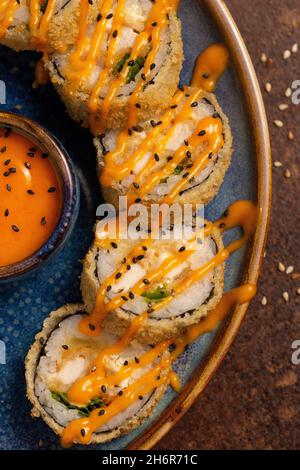 Petits pains de sushi cuits sur une assiette avec sauce gros plan.Aliments sains asiatiques Banque D'Images