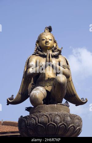 C'est une statue en laiton de 'Garuda' (le véhicule du seigneur 'Vishnu') devant le temple Krishna sur la place Patan Durbar.La statue se trouve sur un piédestal en pierre, à 5 pieds au-dessus du sol, au niveau de la statue du Seigneur Krishna qui se trouve à l'intérieur du temple.Selon la mythologie hindoue, Krishna est une incarnation de Vishnu..8 avril 2007. Banque D'Images