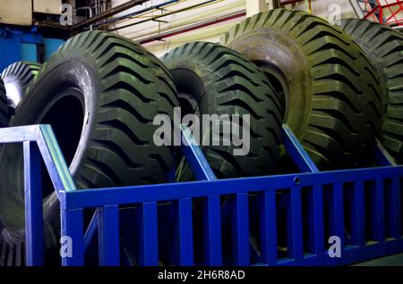 Entrepôt avec pneus pour camions à une installation industrielle pour la production de voitures. Le protecteur d'une grande roue en caoutchouc. Rouleau en caoutchouc de la benne. Banque D'Images