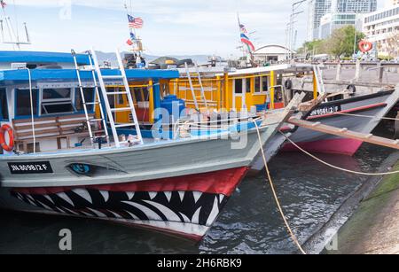 Kota Kinabalu, Malaisie - 23 mars 2019 : bateaux de pêche colorés amarrés près du marché aux poissons KK par une journée ensoleillée Banque D'Images