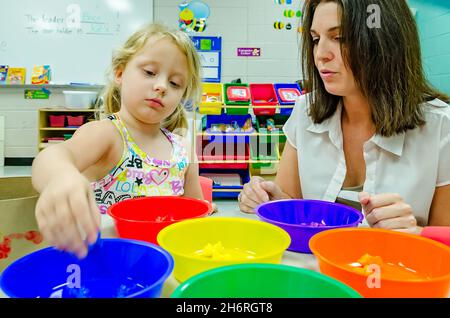 Un professeur de maternelle aide un élève à trier les formes colorées en bols colorés, le 13 août 2012, à Columbus, Mississippi.(Photo de Carmen K. Sisso Banque D'Images