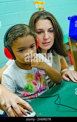 Un professeur de pré-maternelle aide un étudiant à jouer un jeu d'ordinateur pour apprendre les couleurs, 13 août 2012, à Columbus, Mississippi. Banque D'Images