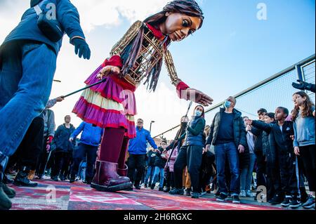 La marionnette géante vue sur un tapis spécial fait pour elle par un groupe d'enfants.Amara, un nouveau centre culturel dans le centre de la Haye a organisé dans le cadre de son 'Open Festival', la visite de la marionnette géante 'Little Amal',Une jeune fille réfugiée syrienne de neuf ans et de plus de 11 mètres de haut au théâtre 'de Vaillant', connu pour sa diversité culturelle, et dans le but d'accroître la participation culturelle de tous les résidents de la Haye.De là, le petit Amal accompagné d'enfants a marché et joué autour du quartier. Banque D'Images