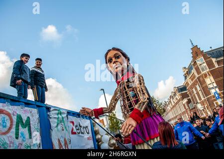 Deux enfants sont vus debout sur un conteneur de navire pour voir le marionnette géant plus proche.Amara, un nouveau centre culturel dans le centre de la Haye a organisé dans le cadre de son 'Open Festival', la visite de la marionnette géante 'Little Amal',Une jeune fille réfugiée syrienne de neuf ans et de plus de 11 mètres de haut au théâtre 'de Vaillant', connu pour sa diversité culturelle, et dans le but d'accroître la participation culturelle de tous les résidents de la Haye.De là, le petit Amal accompagné d'enfants a marché et joué autour du quartier. Banque D'Images