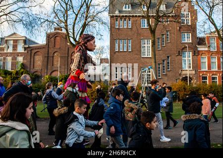 Des enfants sont vus courir près de la marionnette géante.Amare, un nouveau centre culturel au centre de la Haye, a organisé dans le cadre de son « Open Festival », la visite de la marionnette géante « Little Amal », une jeune fille réfugiée syrienne de neuf ans et plus de 11 mètres de haut au théâtre « de Vaillant »,Connue pour sa diversité culturelle et dans le but d'accroître la participation culturelle de tous les habitants de la Haye.De là, le petit Amal accompagné d'enfants a marché et joué autour du quartier.(Photo par Ana Fernandez/SOPA Images/Sipa USA) Banque D'Images