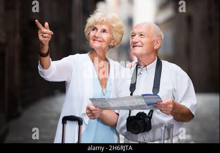 Femme et homme senior voyageant ensemble à la recherche d'une destination avec plan de la ville Banque D'Images