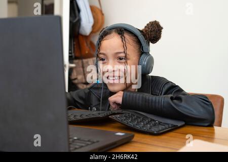 Une jeune fille fréquente la classe pratiquement à la maison pendant la pandémie Covid-19 Banque D'Images