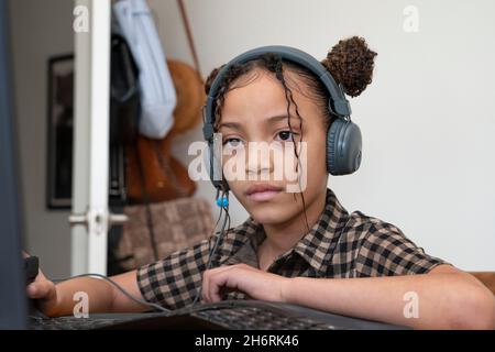 Une jeune fille fréquente la classe pratiquement à la maison pendant la pandémie Covid-19 Banque D'Images