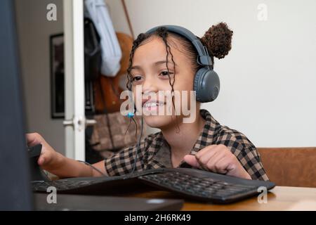 Une jeune fille fréquente la classe pratiquement à la maison pendant la pandémie Covid-19 Banque D'Images