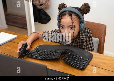 Une jeune fille fréquente la classe pratiquement à la maison pendant la pandémie Covid-19 Banque D'Images