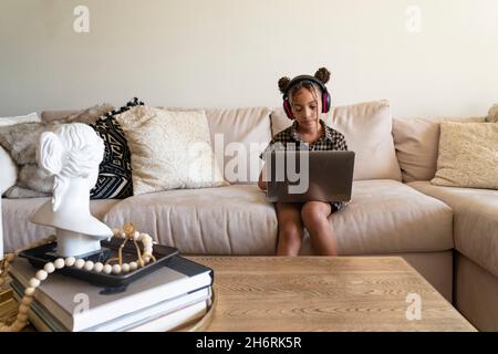 Une jeune fille fréquente la classe pratiquement à la maison pendant la pandémie Covid-19 Banque D'Images