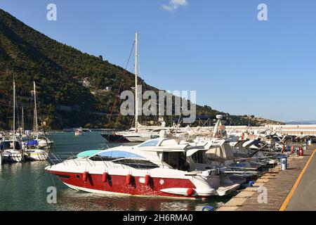 Yachts et voiliers amarrés dans le port de plaisance d'Alassio avec la côte vallonnée en arrière-plan dans une journée ensoleillée d'été, Savona, Ligurie, Italie Banque D'Images