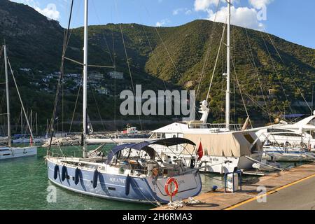 Yachts et voiliers amarrés dans le port de plaisance d'Alassio avec la côte vallonnée en arrière-plan dans une journée ensoleillée d'été, Savona, Ligurie, Italie Banque D'Images