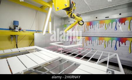 Le bras robotique industriel peint le cadre.Action.Equipement moderne pour la peinture de meubles dans l'entreprise industrielle.Le bras robotique peint du bois peint par pulvérisation Banque D'Images