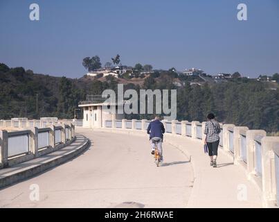 Los Angeles, CA, Etats-Unis - November17, 2021 : un cycliste et un piéton traversent le lac Hollywood via le barrage Mulholland à Los Angeles, CA. Banque D'Images