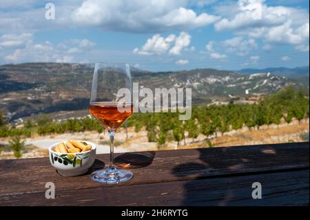 Industrie viticole de l'île de Chypre, dégustation de vin sec de rose sur un domaine viticole avec vue sur les vignobles et les pentes sud de la chaîne de montagnes de Troodos en journée ensoleillée Banque D'Images