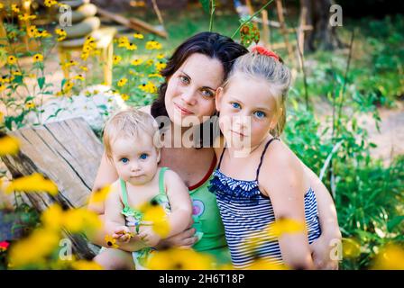 maman dans le jardin et deux filles Banque D'Images