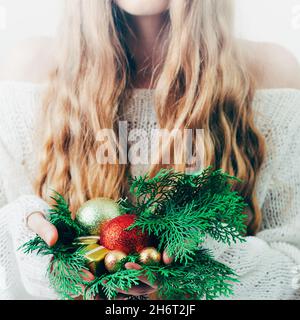 Boîte cadeau Noël ou nouvel an entre les mains d'une femme blonde. Banque D'Images