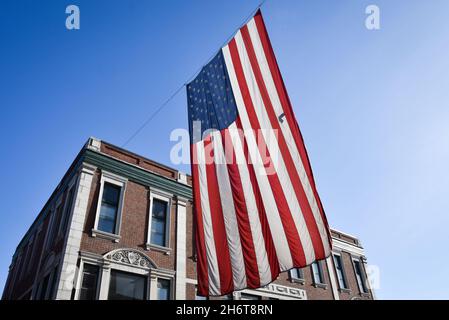 Un grand drapeau américain est suspendu au-dessus de main Street, barre, VT, le Veterans Day. Banque D'Images