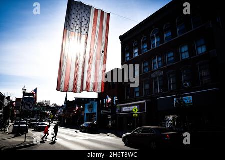 Un grand drapeau américain est suspendu au-dessus de main Street, barre, VT, USA, le Veterans Day. Banque D'Images