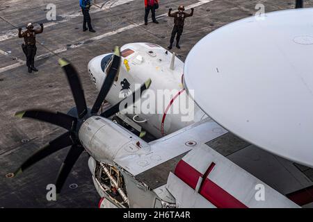 211117-N-YN807-1038 MER DES PHILIPPINES (NOV17, 2021) les marins effectuent des vérifications sur un Hawkeye avancé E-2D, affecté aux « aigles noirs » de l'escadron d'alerte précoce aéroporté du transporteur (VAW) 113, sur le pont de vol du porte-avions USS Carl Vinson de la classe Nimitz (CVN 70), le 17 novembre 2021.Carl Vinson Carrier Strike Group est en cours de déploiement prévu dans la zone d'exploitation de la 7e flotte des États-Unis afin d'améliorer l'interopérabilité par le biais d'alliances et de partenariats tout en servant de force d'intervention prête à l'emploi pour soutenir une région Indo-Pacifique libre et ouverte.(É.-U.Photo de la marine par le Matelot de 1re classe Megan, spécialiste des communications de masse Banque D'Images