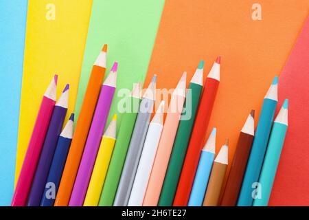 Collection de crayons placés de façon chaotique sur du papier de couleur pour l'art des enfants Banque D'Images