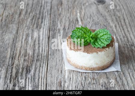 mini-cheesecake décoré de feuilles de menthe sur une table rustique en bois Banque D'Images