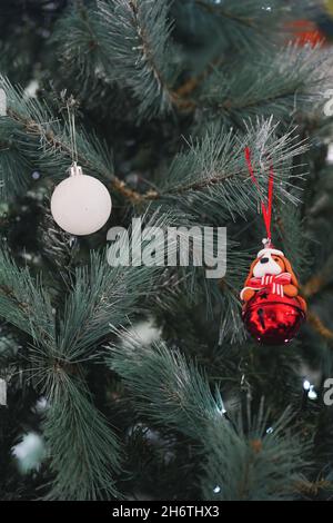 Décoration de Noël avec un chien orné d'un noeud rouge accroché à un arbre de Noël Banque D'Images