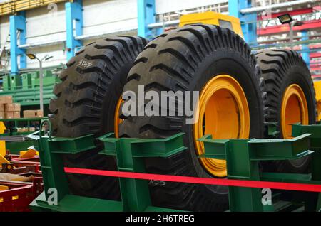 Entrepôt avec pneus pour camions à une installation industrielle pour la production de voitures. Le protecteur d'une grande roue en caoutchouc. Rouleau en caoutchouc de la benne. Banque D'Images