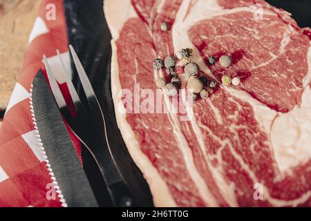 Steak de tomahawk de Wagyu vieilli cru en gros plan sur le tableau noir. Banque D'Images