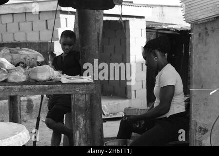 Une mère et une fille vendant des haricots gâteau dans la rue de Lagos, Nigeria Banque D'Images