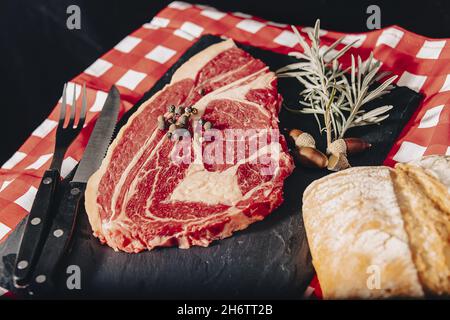 Steak de tomahawk de Wagyu vieilli cru en gros plan sur le tableau noir. Banque D'Images
