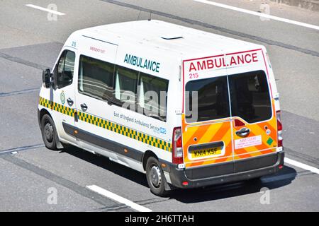 Vue latérale arrière et vue aérienne est de l'Angleterre transfert de patient type ambulance sanitaire NHS avec marquages de véhicule haute visibilité sur l'autoroute britannique Banque D'Images