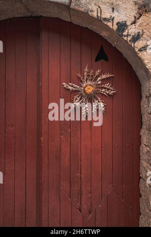 Porte européenne rétro en bois et fond de mur en pierre avec une décoration de fleur sèche Banque D'Images